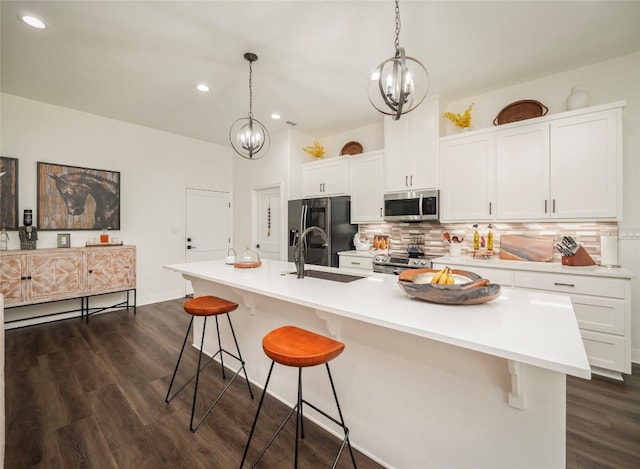 kitchen featuring stainless steel appliances, a breakfast bar area, a kitchen island with sink, and sink