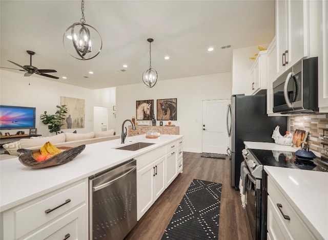 kitchen featuring hanging light fixtures, appliances with stainless steel finishes, sink, and white cabinets