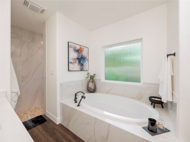 bathroom featuring hardwood / wood-style flooring and shower with separate bathtub