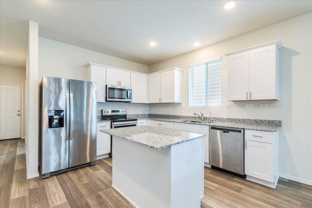 kitchen featuring light stone counters, appliances with stainless steel finishes, and white cabinets