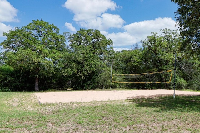 surrounding community with a yard and volleyball court