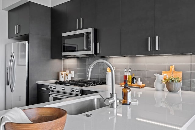 kitchen featuring tasteful backsplash, appliances with stainless steel finishes, and sink