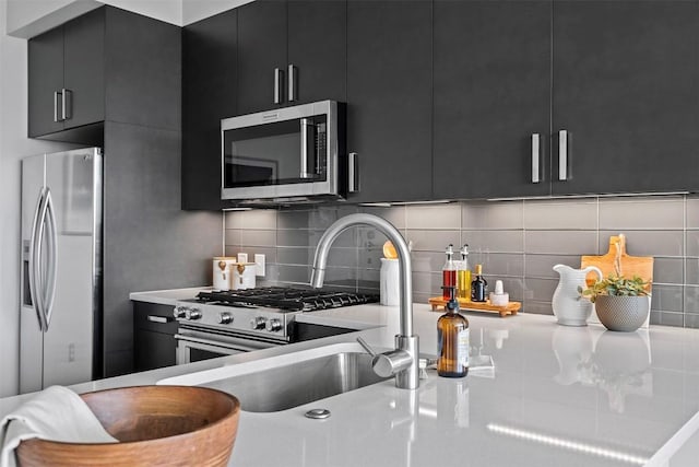 222 W Ave Unit 1404, Austin, TX 78701 - kitchen with dark cabinetry, appliances with stainless steel finishes, light countertops, decorative backsplash, and modern cabinets