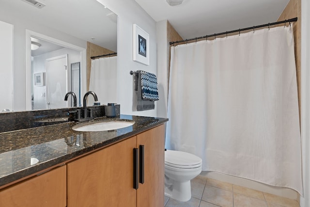 bathroom with vanity, toilet, a shower with shower curtain, and tile patterned floors