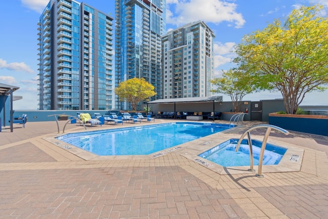 view of pool with a patio and a community hot tub