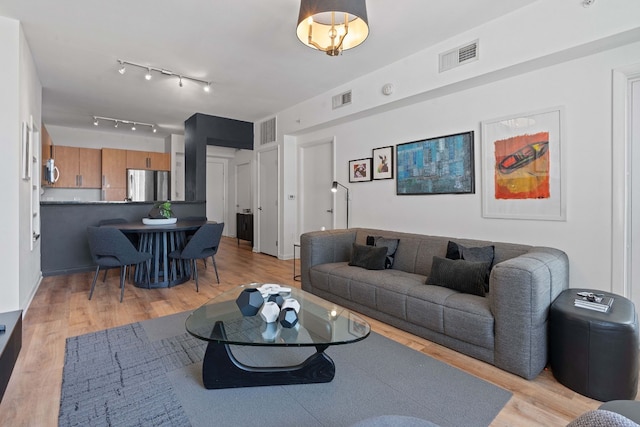 living room with visible vents and light wood-style floors