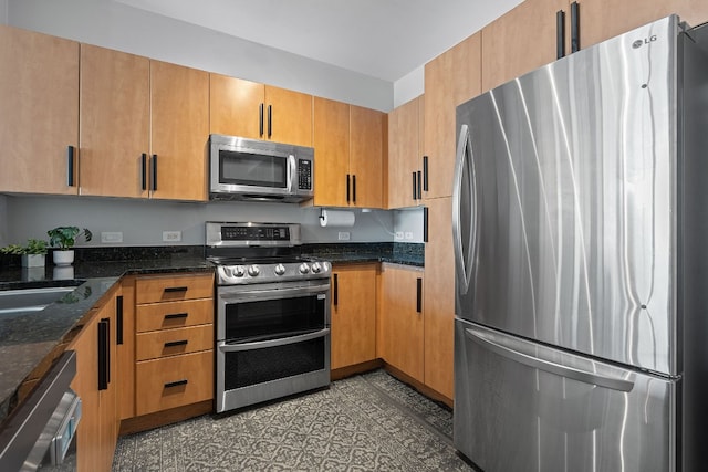 kitchen featuring dark stone countertops and appliances with stainless steel finishes