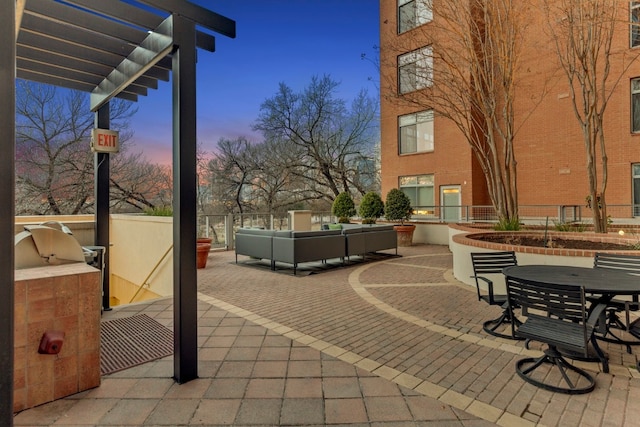 patio terrace at dusk featuring area for grilling