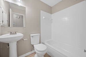 bathroom featuring tub / shower combination and toilet