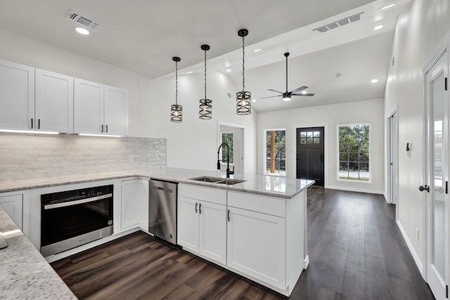 kitchen with kitchen peninsula, dark hardwood / wood-style flooring, stainless steel appliances, sink, and white cabinets