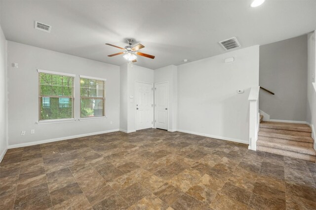 spare room featuring visible vents, baseboards, and stairway