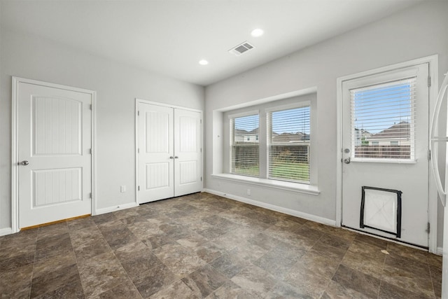 foyer entrance featuring recessed lighting, visible vents, baseboards, and stone finish floor