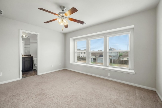 empty room with light carpet, visible vents, ceiling fan, and baseboards