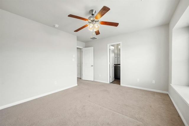 unfurnished bedroom featuring a ceiling fan, baseboards, visible vents, ensuite bath, and light carpet