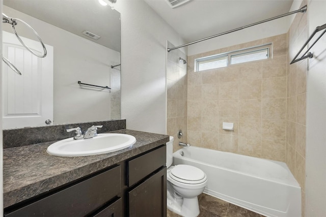 full bathroom featuring vanity, tiled shower / bath combo, toilet, and tile patterned flooring