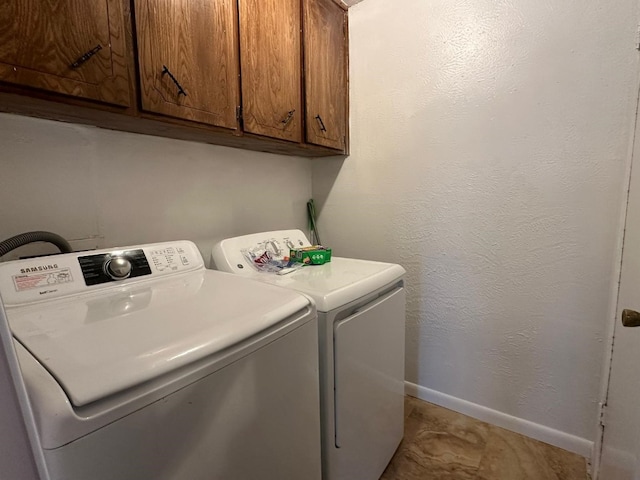 washroom with cabinets and washing machine and dryer