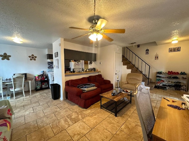 living room with ceiling fan and a textured ceiling