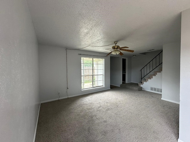 empty room with ceiling fan, a textured ceiling, and carpet