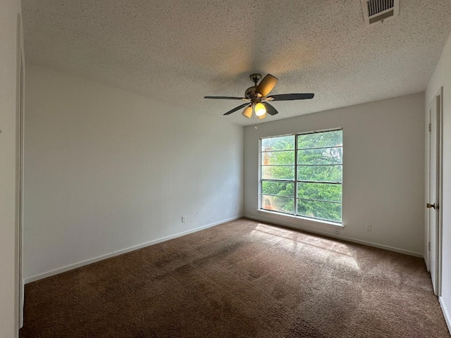 spare room featuring ceiling fan, carpet, and a textured ceiling