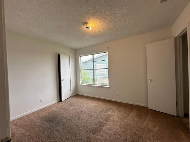 unfurnished bedroom featuring carpet and a textured ceiling