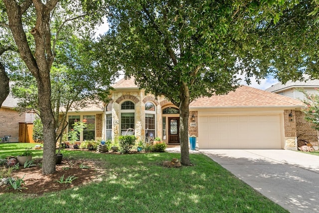 view of front of house featuring a garage and a front lawn