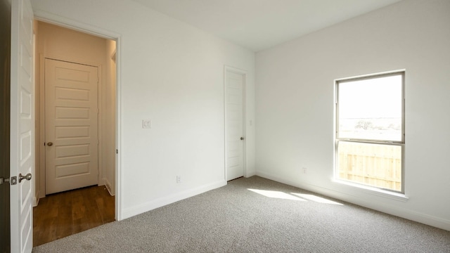 unfurnished bedroom featuring dark carpet