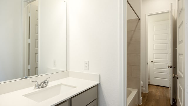 bathroom with vanity, tiled shower / bath combo, and wood-type flooring