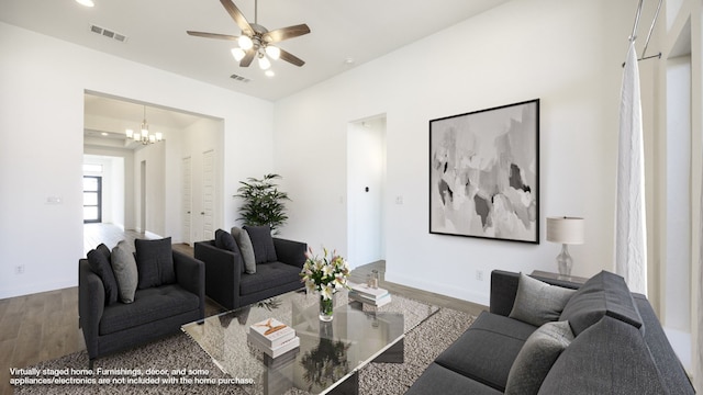 living room featuring wood-type flooring and ceiling fan with notable chandelier