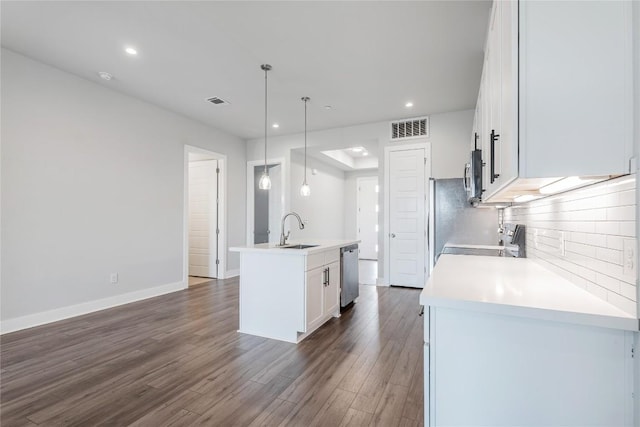 4507 E Martin Luther King Jr Blvd Unit 122, Austin, TX 78721 - kitchen featuring stainless steel appliances, a sink, a kitchen island with sink, white cabinetry, and dark wood-style floors