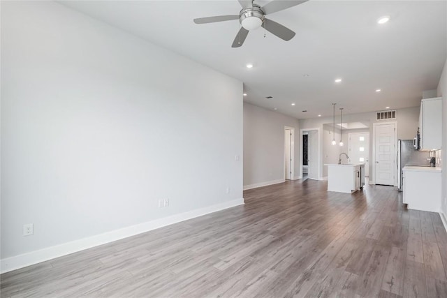 4507 E Martin Luther King Jr Blvd Unit 122, Austin, TX 78721 - unfurnished living room featuring wood finished floors, a ceiling fan, and recessed lighting
