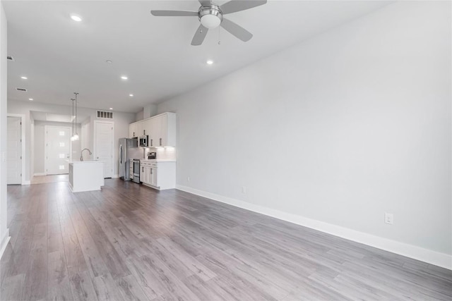 4507 E Martin Luther King Jr Blvd Unit 122, Austin, TX 78721 - unfurnished living room featuring a ceiling fan, wood finished floors, baseboards, and recessed lighting