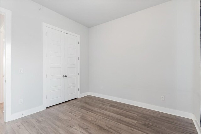 4507 E Martin Luther King Jr Blvd Unit 122, Austin, TX 78721 - unfurnished bedroom featuring wood finished floors, baseboards, and a closet