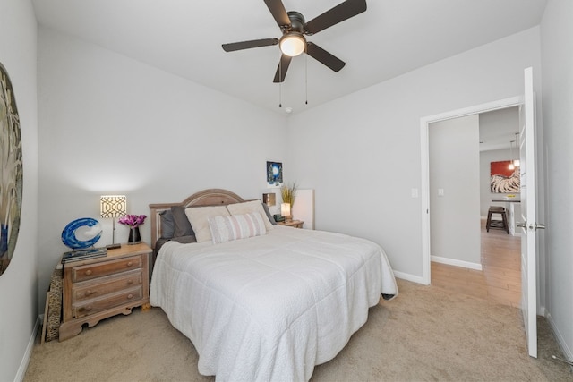 bedroom featuring baseboards, ceiling fan, and light colored carpet