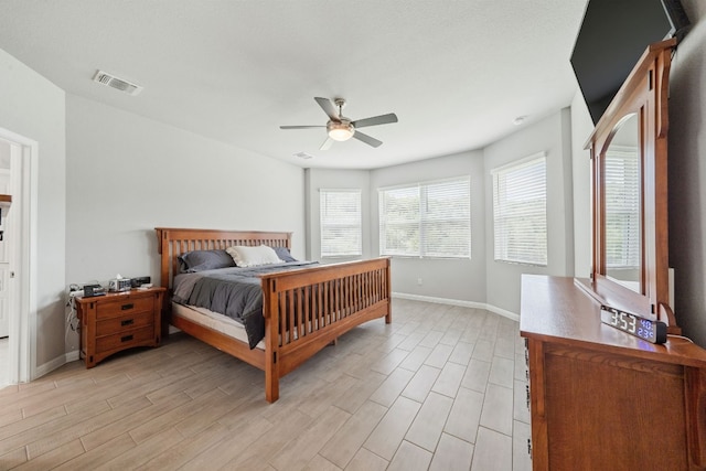 bedroom with light wood-type flooring, visible vents, and baseboards