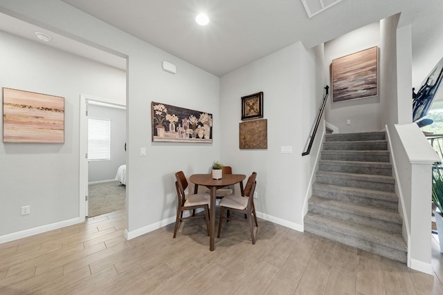 dining area with visible vents, stairway, light wood-style flooring, and baseboards