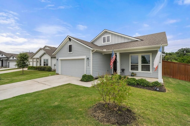 view of front of property with driveway, a garage, fence, a front lawn, and board and batten siding