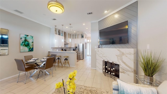 dining area featuring crown molding and light wood-type flooring