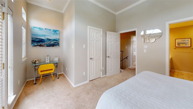 bedroom featuring crown molding, ensuite bath, light colored carpet, and a high ceiling