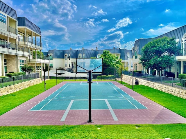 view of tennis court featuring a yard and basketball hoop