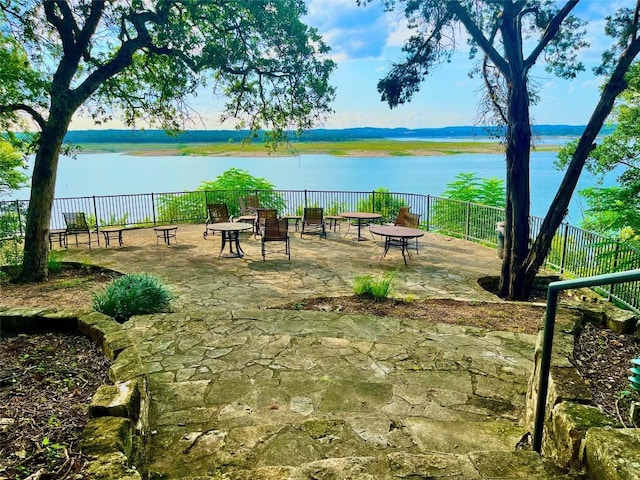 surrounding community featuring a water view and a patio area