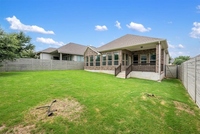 rear view of house featuring a yard