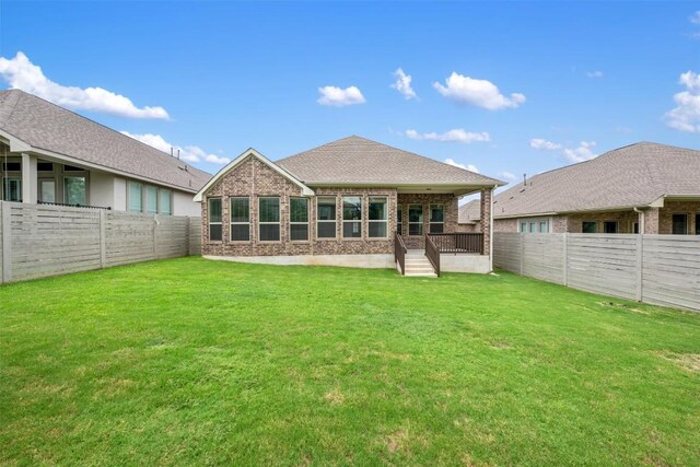 rear view of house featuring a lawn