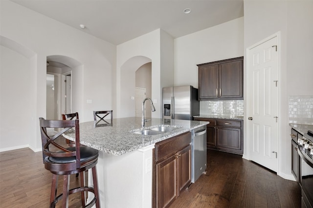 kitchen featuring backsplash, dark hardwood / wood-style flooring, stainless steel appliances, and sink