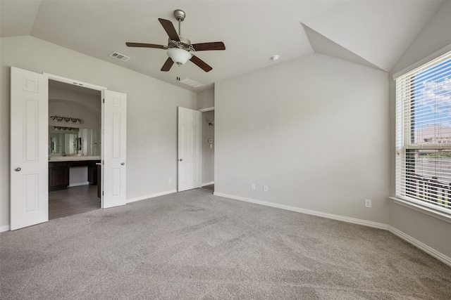 unfurnished bedroom with ensuite bath, lofted ceiling, ceiling fan, and carpet floors