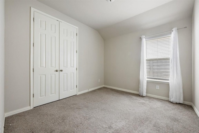 unfurnished bedroom with light colored carpet and a closet