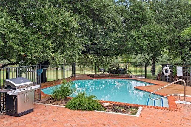 pool with a patio, a fenced backyard, and area for grilling