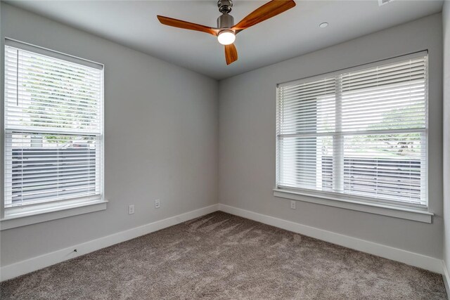 carpeted spare room featuring ceiling fan