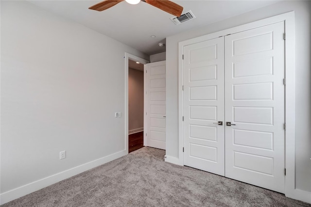 unfurnished bedroom featuring light carpet, a closet, and ceiling fan