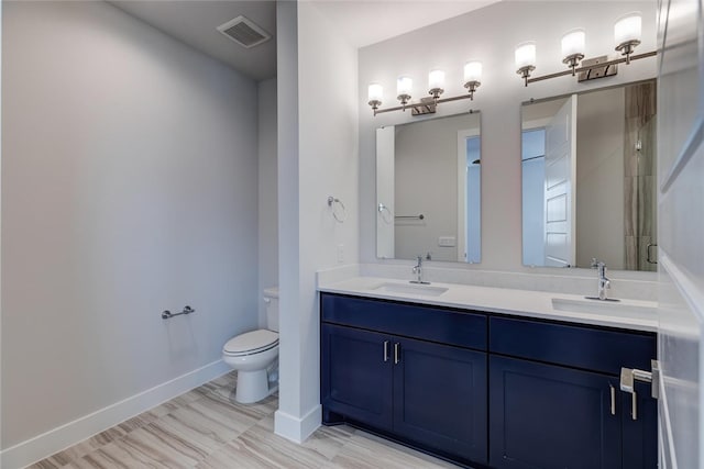 bathroom featuring dual vanity, toilet, and tile patterned floors