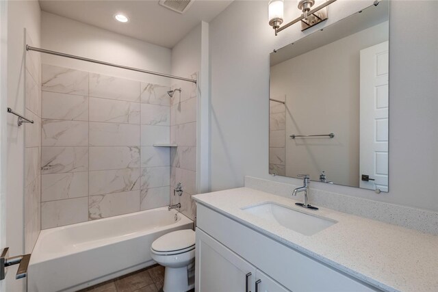 full bathroom with vanity, tiled shower / bath, tile patterned floors, and toilet